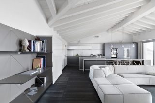 interior shots of a modern living room in the attic with wooden floor and ceiling with wooden beams, on the right side there is a sofa in the background the kitchen with island kitchen